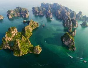 Aerial view floating fishing village and rock island, Halong Bay, Vietnam, Southeast Asia. UNESCO World Heritage Site. Junk boat cruise to Ha Long Bay. Popular landmark, famous destination of Vietnam Aerial view floating fishing village and rock island, Halong Bay, Vietnam, Southeast Asia. UNESCO World Heritage Site. Junk boat cruise to Ha Long Bay. Popular landmark, famous destination of Vietnam
