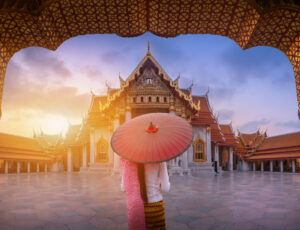 Woman with red umbrella at entrance of Marble Temple, Bangkok