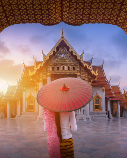 Woman with red umbrella at entrance of Marble Temple, Bangkok Woman with red umbrella at entrance of Marble Temple, Bangkok