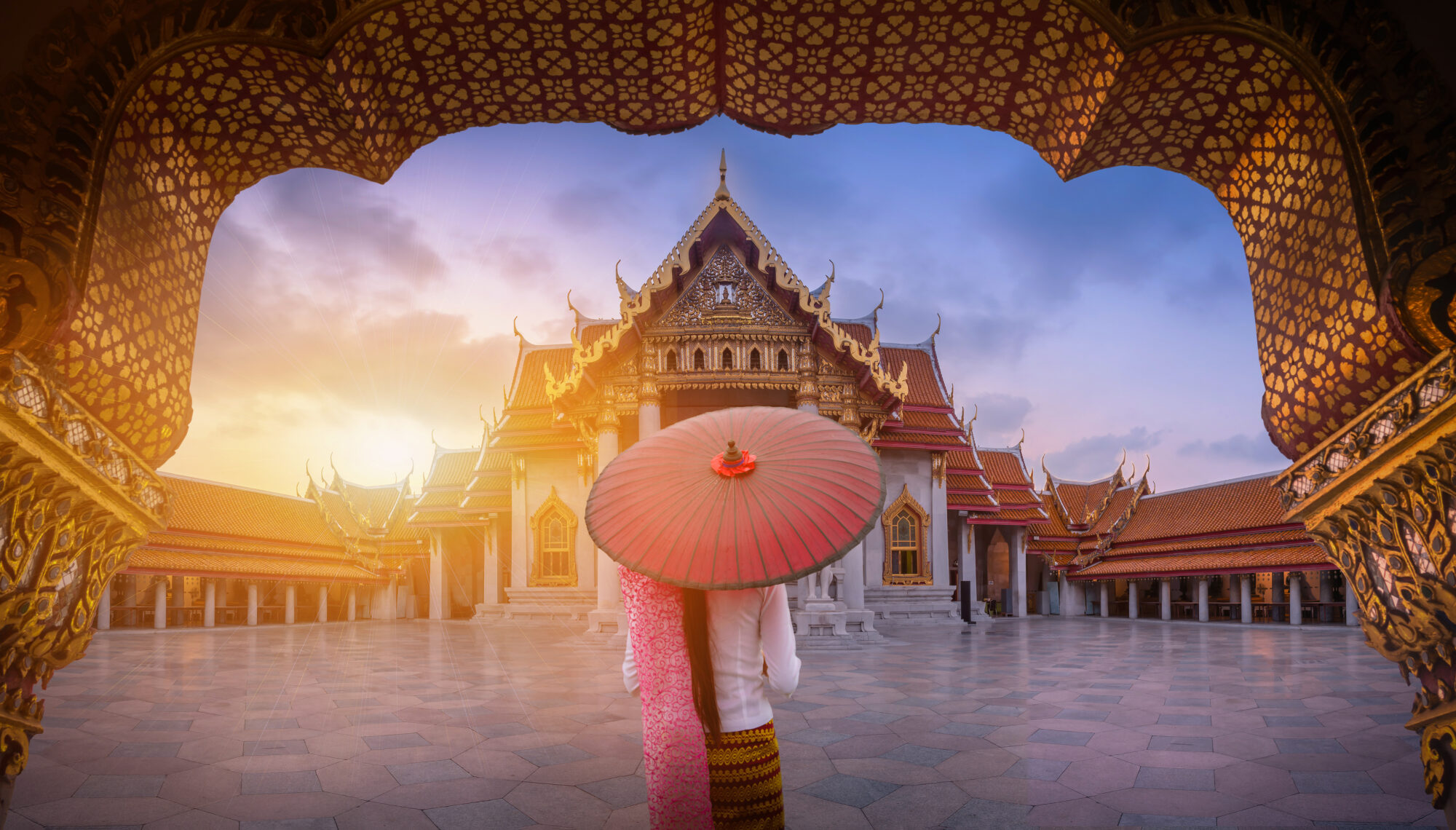 Woman with red umbrella at entrance of Marble Temple, Bangkok