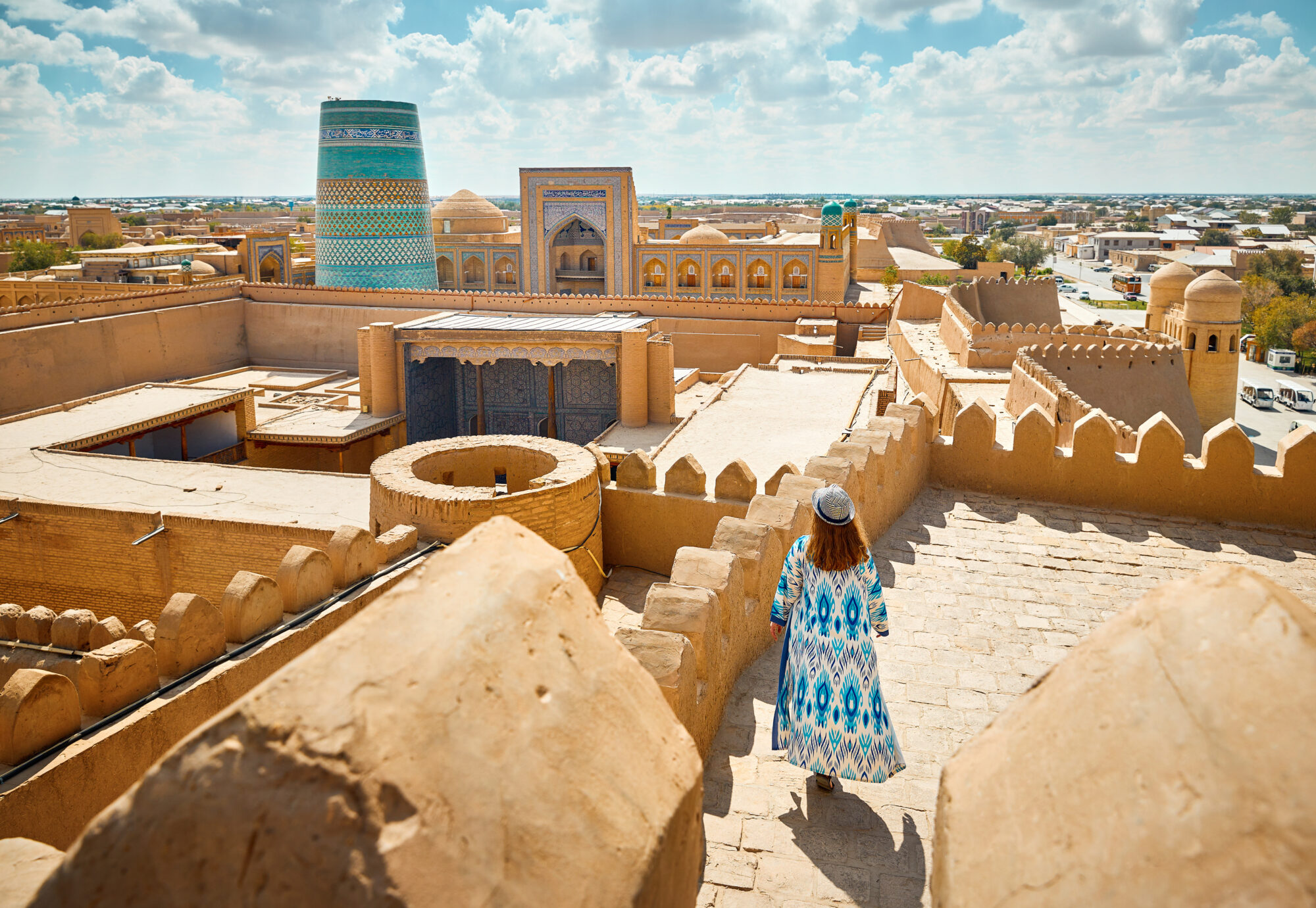 Tourist in ethnic dress at city walls Ichan Kala of Khiva