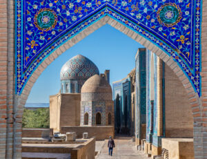 View over the mausoleums and domes of the historical cemetery of Shahi Zinda through an arched gate, Samarkand, Uzbekistan View over the mausoleums and domes of the historical cemetery of Shahi Zinda through an arched gate, Samarkand, Uzbekistan