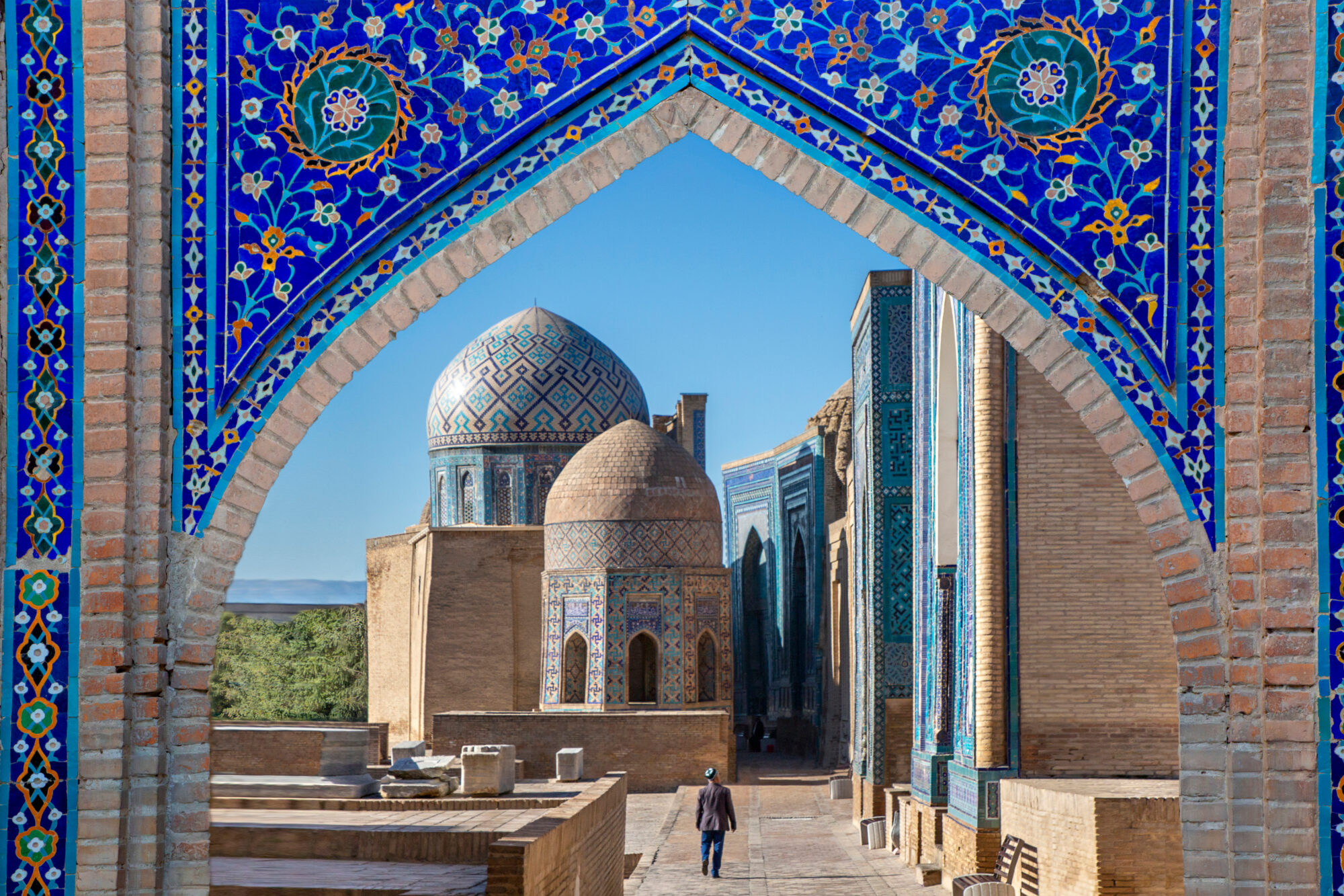 View over the mausoleums and domes of the historical cemetery of Shahi Zinda through an arched gate, Samarkand, Uzbekistan View over the mausoleums and domes of the historical cemetery of Shahi Zinda through an arched gate, Samarkand, Uzbekistan