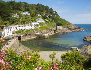 Entrance to Polperro harbour Cornwall UK with clear blue green s