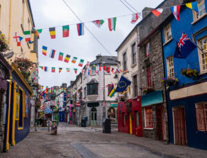 View of the main high street in Galway City with the brightly painted buildings and cobblestone streets on a cloudy day
